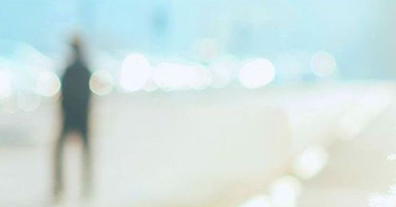 Blurry, unclear scene with a silhouette in the background, evoking a sense of uncertainty or dreaminess.